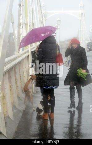 Londres, Royaume-Uni. 5 mars, 2017. Les Londoniens pris dans pluie torrentielle sur Albert Bridge le dimanche après-midi. Credit : JOHNNY ARMSTEAD/Alamy Live News Banque D'Images