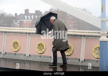 Londres, Royaume-Uni. 5 mars, 2017. Les Londoniens pris dans pluie torrentielle sur Albert Bridge le dimanche après-midi. Credit : JOHNNY ARMSTEAD/Alamy Live News Banque D'Images