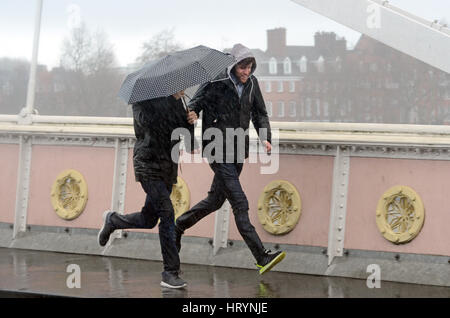 Londres, Royaume-Uni. 5 mars, 2017. Les Londoniens pris dans pluie torrentielle sur Albert Bridge le dimanche après-midi. Credit : JOHNNY ARMSTEAD/Alamy Live News Banque D'Images