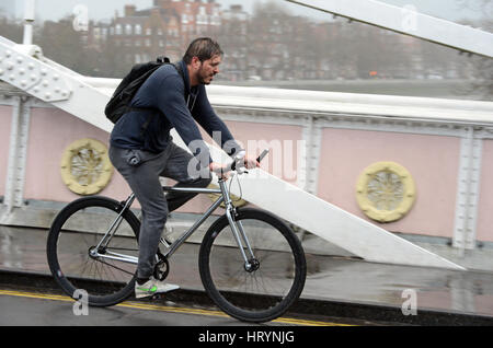 Londres, Royaume-Uni. 5 mars, 2017. Les Londoniens pris dans pluie torrentielle sur Albert Bridge le dimanche après-midi. Credit : JOHNNY ARMSTEAD/Alamy Live News Banque D'Images