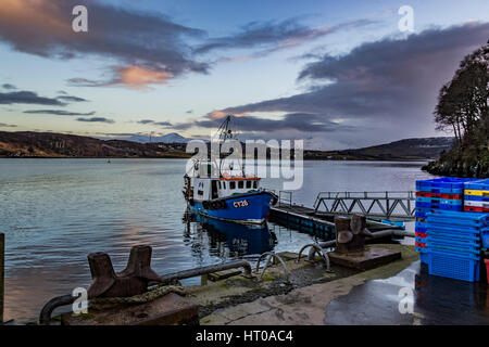 Montagnes Cuillin Hills, sur le Loch Portree, sur l'île de Skye, en Écosse, contre un ciel dramatique, en face de Portree Harbour landing stage. Banque D'Images