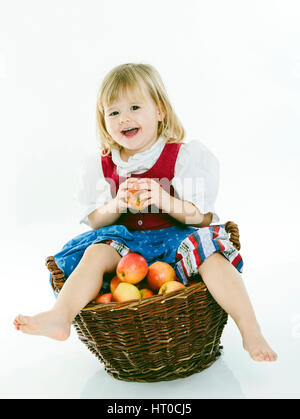 M‰dchensitzt Apfelkorb in Dirndl gi - fille en costume avec Apple Banque D'Images