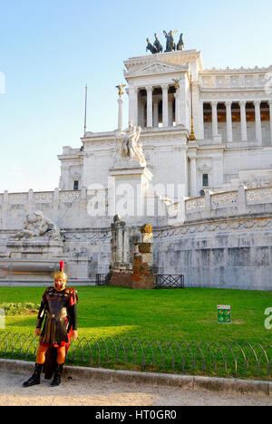 L'ÉPOQUE VICTORIENNE, monument de Vittorio Emanuele, ROME. Un homme déguisé en centurion romain EFFECTUE LE PAIEMENT POUR LES TOURISTES. Banque D'Images