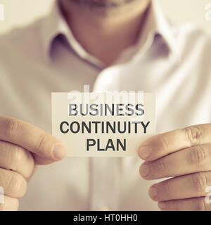Gros plan sur businessman holding une carte avec texte PLAN DE CONTINUITÉ D'ACTIVITÉ, concept d'entreprise image avec arrière-plan flou et vintage tone Banque D'Images