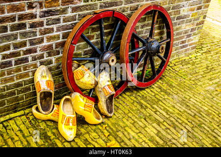 Ancien en bois peint jaune Chaussures néerlandais en appui sur roues de charrette en bois cerclées d'acier avec des rayons en bois Banque D'Images