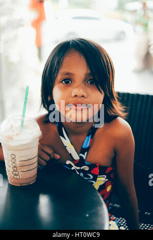 Cute little girl shake chocolat froid glace potable dans un café Banque D'Images