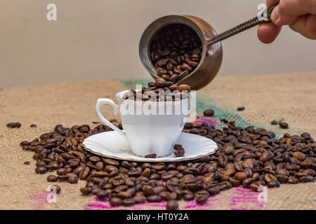 Résumé . Hand pouring Coffee beans à partir de pot de café tasse Banque D'Images