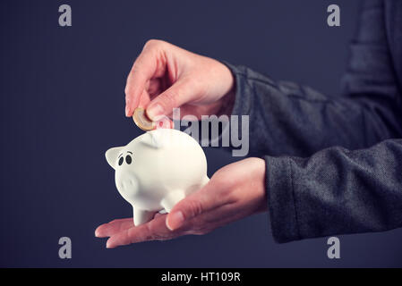 Businesswoman putting un euro coins in piggy bank, d'épargne et de l'argent accueil concept budgétaire Banque D'Images