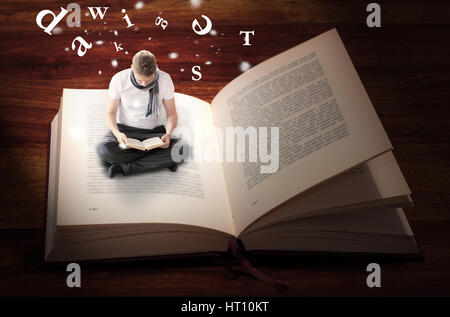 Homme assis et de la lecture à l'intérieur de livre Banque D'Images