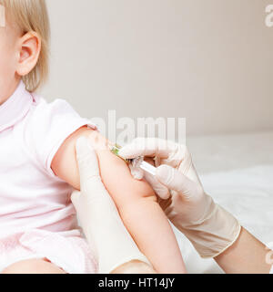 Close-up shot de pédiatre en donnant une injection intramusculaire d'un vaccin pour une petite fille Banque D'Images