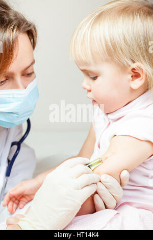 Close-up shot de pédiatre en donnant une injection intramusculaire d'un vaccin pour une petite fille Banque D'Images