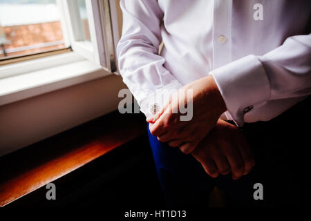 Groom porter cufflink close up shot avec vue sur la mer Banque D'Images