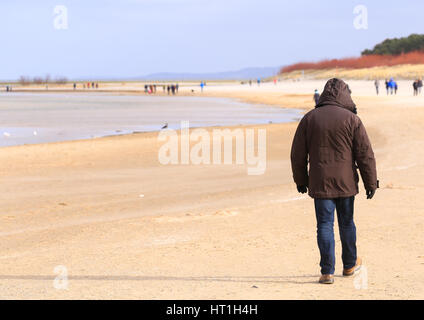 Un homme sur la plage de Swinoujscie, Pologne. Banque D'Images