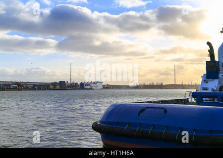 Swinoujscie, Pologne - 21 Février 2017 : un remorqueur à l'embarcadère, le port. Dans l'arrière-plan un car-ferry en attente d'être chargée. Banque D'Images