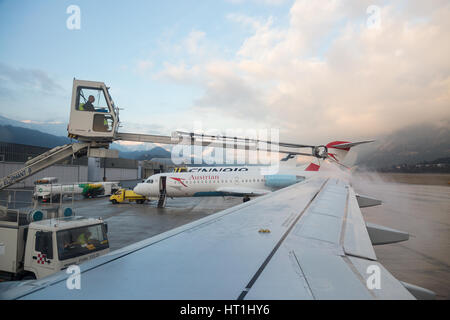 INNSBRUCK, Autriche - 25 février 2017 : véhicule de dégivrage de la pulvérisation sur une aile d'avion avant de décoller à l'aéroport d'Innsbruck. Banque D'Images