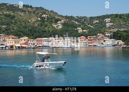 Un petit bateau tête hors de Gaios Harbour sur l'île grecque de Paxos. Banque D'Images