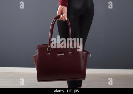 Vogue girl wearing leggings et holding brown sac élégant Banque D'Images