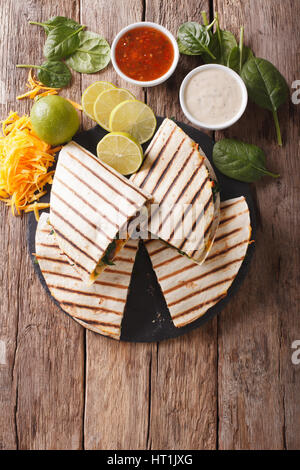 Quesadilla mexicaine avec les épinards, les haricots et le fromage cheddar gros plan sur la table. vertical Vue de dessus Banque D'Images