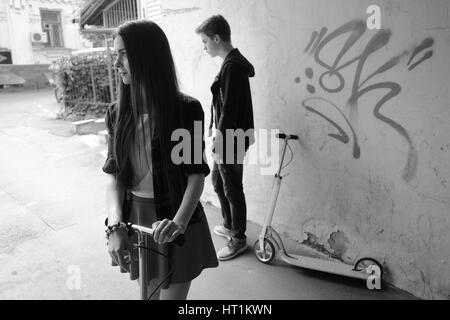 Les adolescents sur l'entraînement kick scooter. Noir et blanc. Banque D'Images