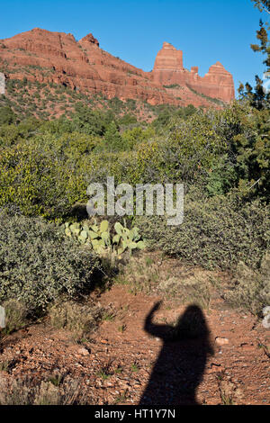 Ombre d'une femme brandissant voyageur à Sedona, Arizona, sur un sentier à Schnebly Hill Road. Montagnes de roche rouge et bleu ciel. Banque D'Images