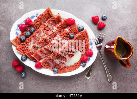 Matin le velours rouge des crêpes sur une plaque recouverte de crème vanille, framboises et bleuets. Petit-déjeuner sain Banque D'Images