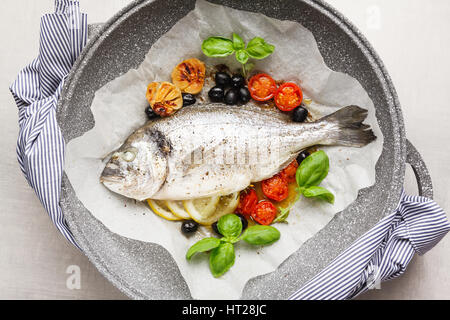 Les poissons la Bram, cuit dans une casserole avec les légumes et le citron, olives noires. Le basilic frais . Dîner santé Banque D'Images