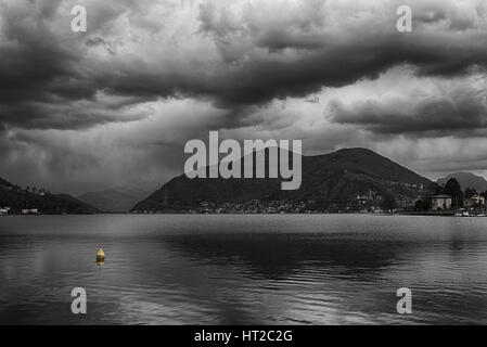 L'après-midi nuageux sur le lac de Lugano avec du jaune bouée flottante, Porto Ceresio - Varèse - Italie Banque D'Images