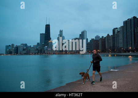 Chicago, USA. 7 mars, 2017. Un jogger exécute son chien le long du lac Michigan au petit matin à Chicago, Illinois, United States, le 7 mars 2017. Pour la première fois en 146 ans, le U.S. National Weather Service documenté pas de neige au sol à Chicago en janvier et février. Credit : Ting Shen/Xinhua/Alamy Live News Banque D'Images