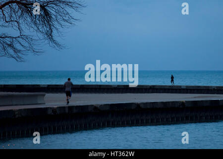 Chicago, USA. 7 mars, 2017. Glissières de jogging le long du lac Michigan au petit matin à Chicago, Illinois, United States, le 7 mars 2017. Pour la première fois en 146 ans, le U.S. National Weather Service documenté pas de neige au sol à Chicago en janvier et février. Credit : Ting Shen/Xinhua/Alamy Live News Banque D'Images