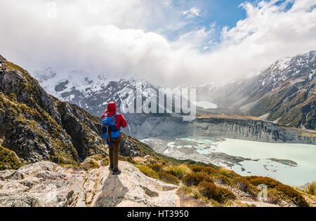 Debout sur les rochers, randonneur vue dans la vallée de Hooker Sealy Tarns Track, lacs glaciaires Mueller et le lac Hooker Lake Banque D'Images