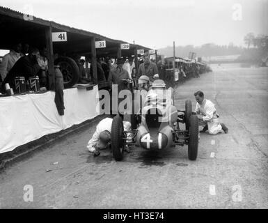 Mécaniciens travaillant sur la MG de Doreen Evans, JCC International Trophy, Brooklands, 1936. Artiste : Bill Brunell. Banque D'Images