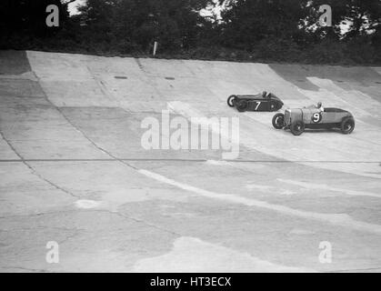 Austin 747 cc works racer et une autre voiture sur les membres d'avion à Brooklands. Artiste : Bill Brunell. Banque D'Images