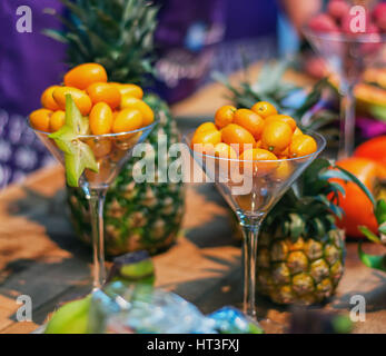 Orange naine connue comme la SLA kumquats servi dans un verre avec de l'ananas sur l'arrière-plan Banque D'Images