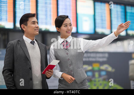 Hôtesse de l'air souriant et passager Banque D'Images