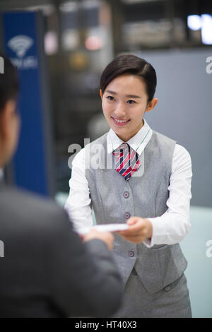 Hôtesse de l'air souriant et passager Banque D'Images