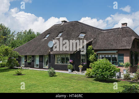 Façade de l'ancienne maison d'habitation avec un toit de chaume dans un petit village néerlandais de Giethoorn. Banque D'Images