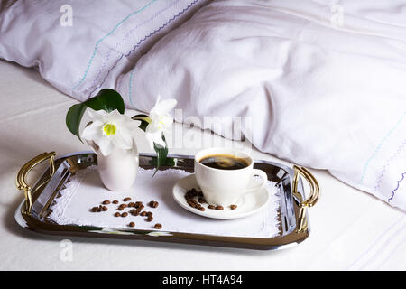 Café du matin au lit sur argent élégant servant des bac. Tasse de café sur une serviette brodée comme meilleur hôtel service concept. Banque D'Images