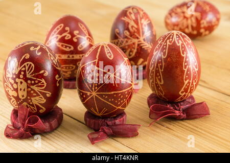 Les oeufs de Pâques peints en rouge de cire dans les titulaires sur mesure Banque D'Images