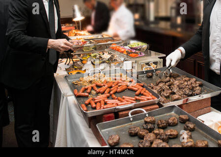 Les personnes qui prennent de la nourriture dans la restauration Buffet salle manger partie. Buffet d'événements Concept. Banque D'Images