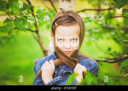 Portrait de jeune fille drôle de printemps. Libre de belles jeunes posant pour la caméra isolé sur fond d'herbe verte. Âge de kid est 11 ans. Banque D'Images