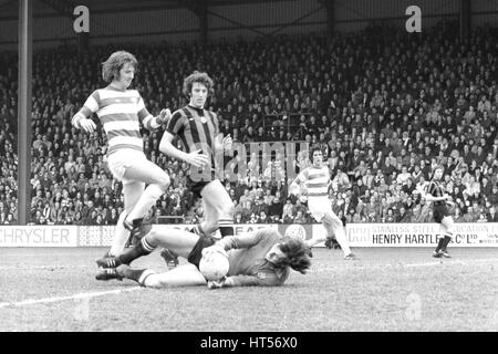 Manchester City le gardien de but Joe Corrigan est un coffre-fort prise sur la balle comme il l'embrayages des pieds de QPR Stan Bowles, gâche durant cet après-midi's League Division One match à Loftus Road. Le joueur au centre-ville est Tommy Stand. Une 81e minute coupe de Dave Webb a décroché la victoire de l'équipe locale. Banque D'Images