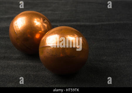 Paire de boules baoding chant chinois de cuivre de la santé pour les mains sur fond noir Banque D'Images