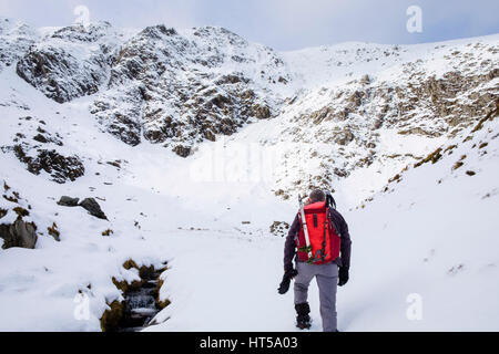Randonnée randonneur en hiver la neige en mcg Clyd Y Garn escalade en montagne montagnes de Snowdonia National Park. Le Nord du Pays de Galles, Royaume-Uni, Angleterre Banque D'Images
