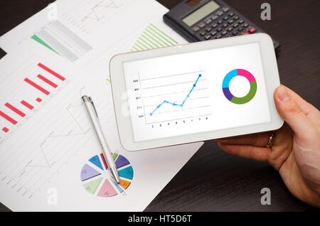 Businessman working with tablet pc. Diagrammes en arrière-plan Banque D'Images