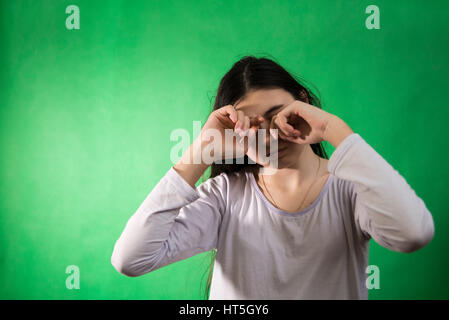 Fille dans sa nuisette veut dormir et se frotte les yeux sur un fond vert d'incrustation isolée Banque D'Images