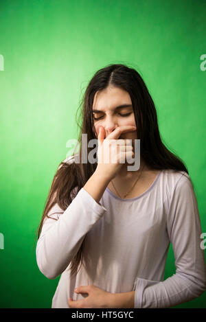 Fille dans sa nuisette veut dormir et bâille sur un fond vert d'incrustation isolée Banque D'Images