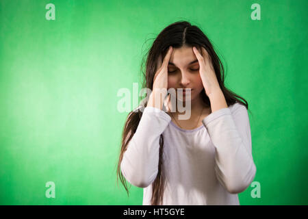 Fille dans sa nuisette veut dormir et se frotte les yeux sur un fond vert d'incrustation isolée Banque D'Images