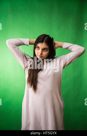 Teen girl in nuisette comb cheveux à fond chroma key vert Banque D'Images