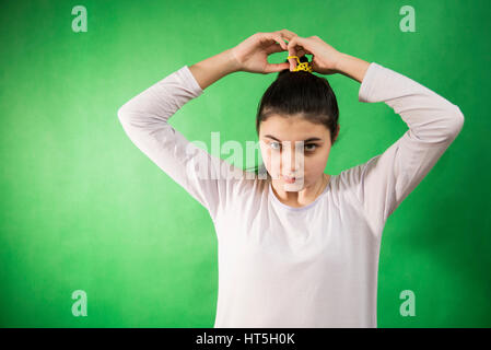 Teen girl in nuisette comb cheveux à fond chroma key vert Banque D'Images