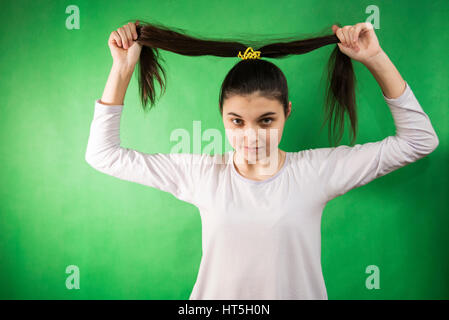 Teen girl in nuisette comb cheveux à fond chroma key vert Banque D'Images